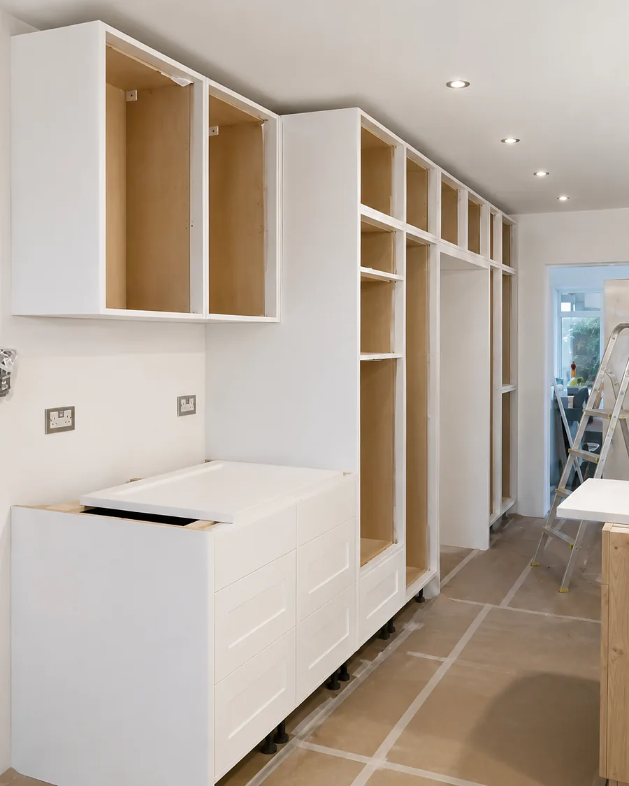 Full-height cabinetry being fitted and scribed in