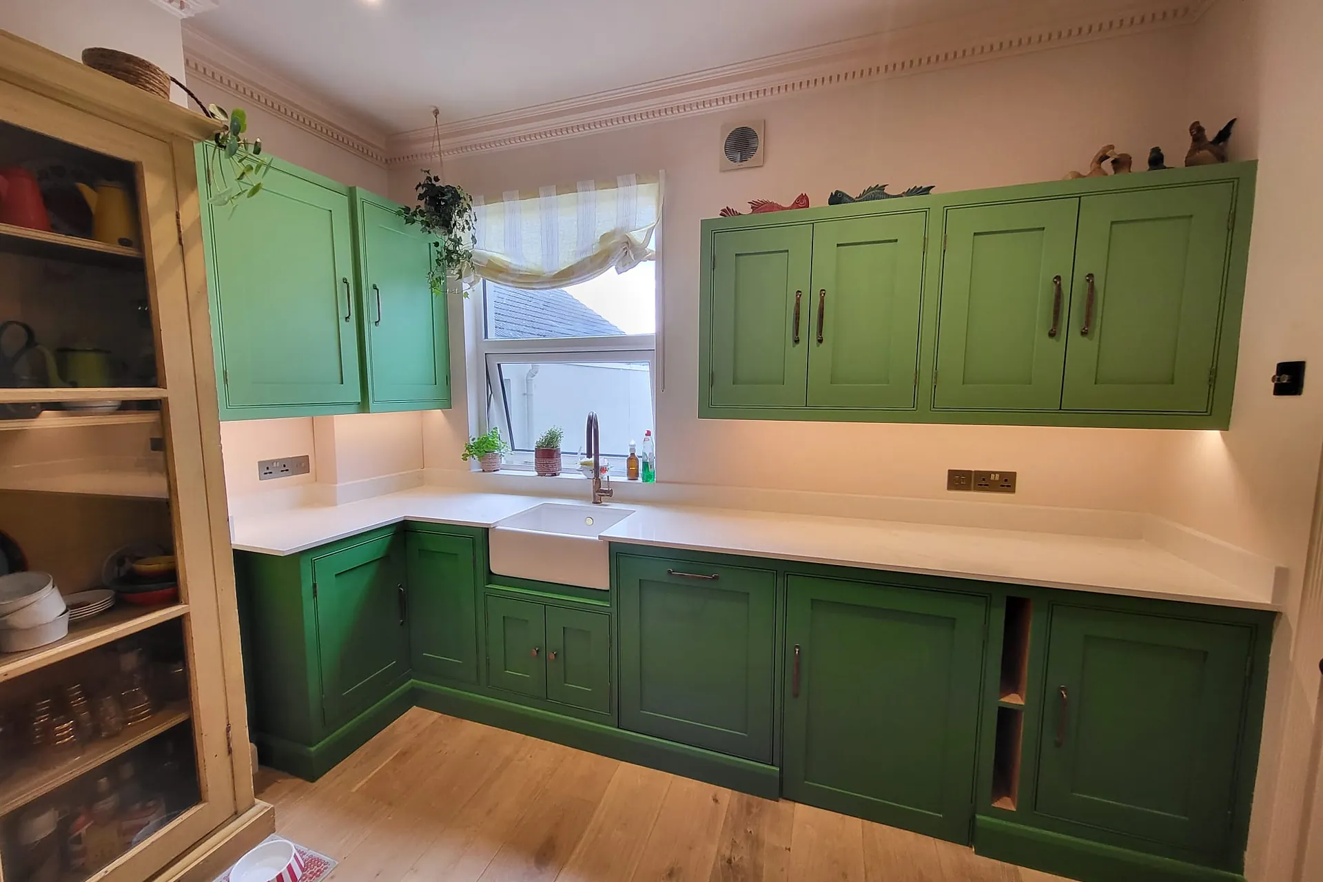 Deep green painted kitchen with butler sink and oak dresser