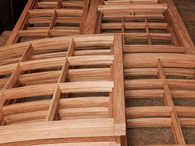 Machined timber frames stacked in the workshop